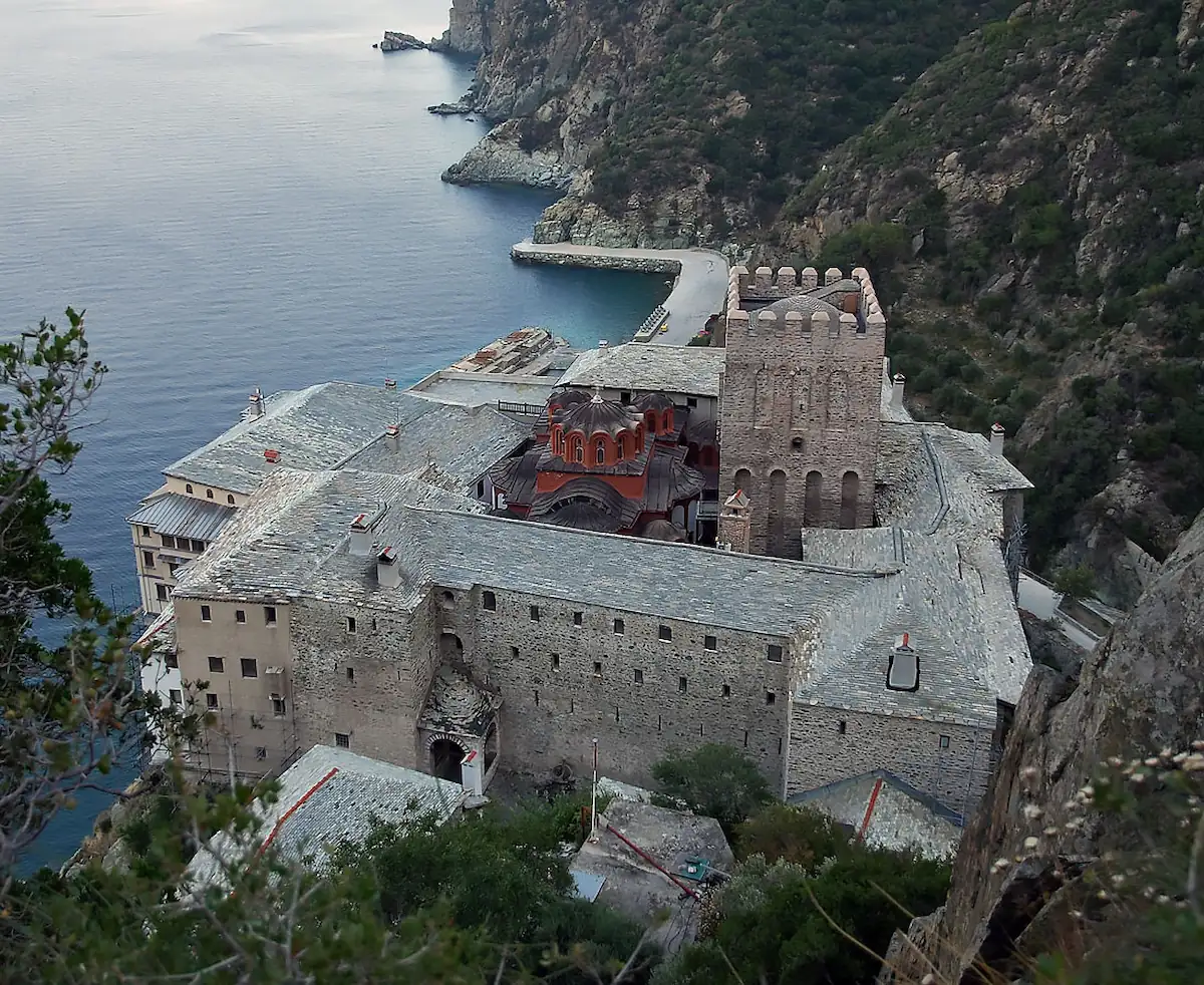 High-angle view of Mount Athos Dionysiou Monastery built on a steep cliff by the sea.