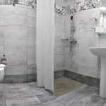 Tiled bathroom and shower area in the family apartment at Prosforio Rooms in Ouranoupoli.