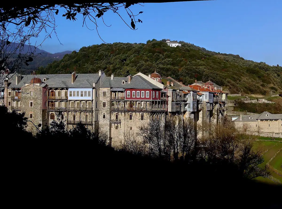 Panoramic view of the historic Iviron Monastery with traditional colorful balconies built on a green hillside of Mount Athos Greece