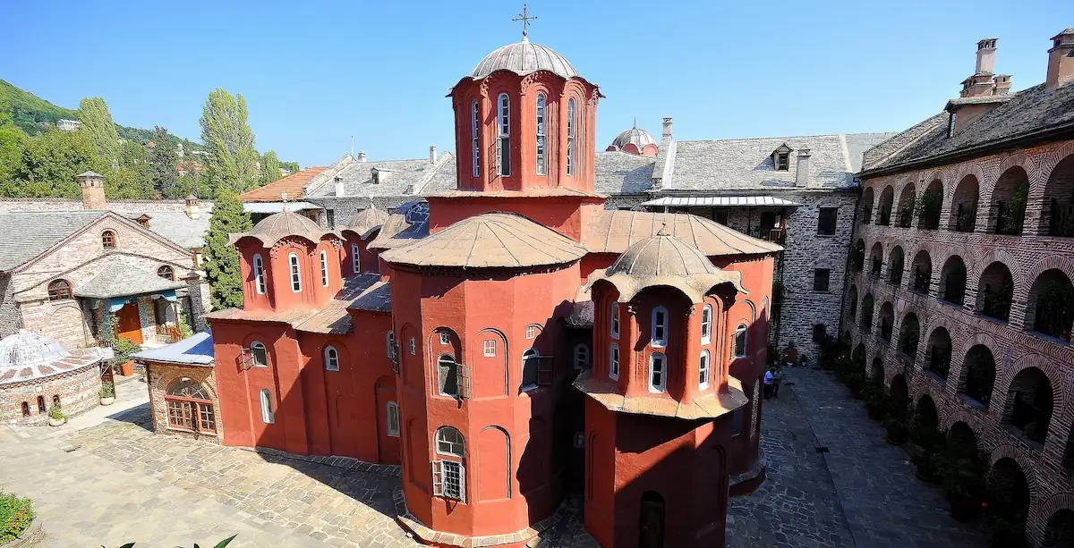 Courtyard view of the historic red brick church and surrounding buildings at Koutloumousiou Monastery, Mount Athos.