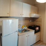 Twin apartment ktchenette at Prosforio Rooms in Ouranoupoli featuring a refrigerator, a sink, and cabinets.